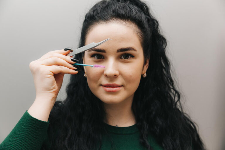 closeup beautiful girl holding eyebrow tweezer her hand near her face studio