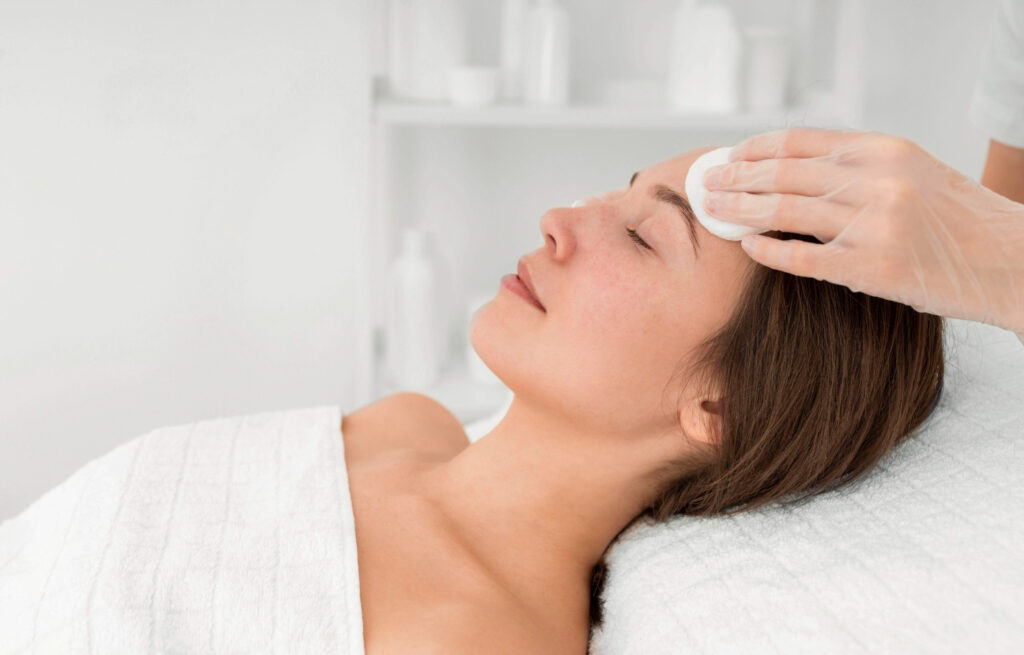 female client salon face care routine with cleansing disks