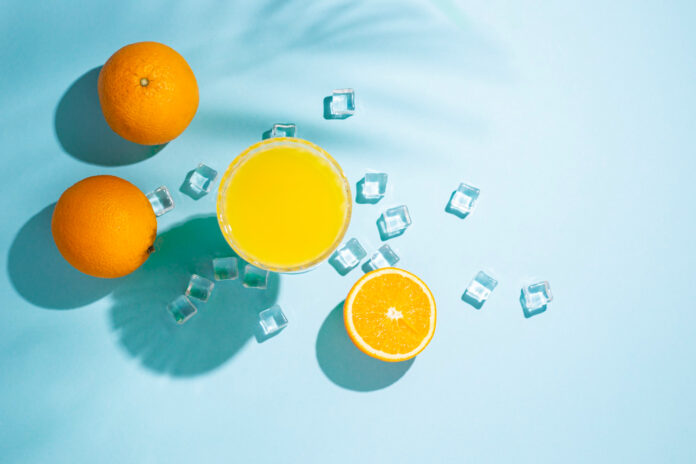 glass with orange cocktail orange ice cubes