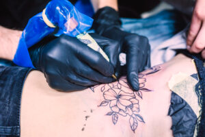 hands making tattoo with machine