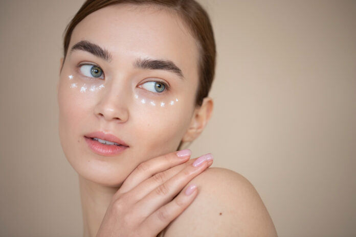 portrait beautiful woman with clear skin using eye cream