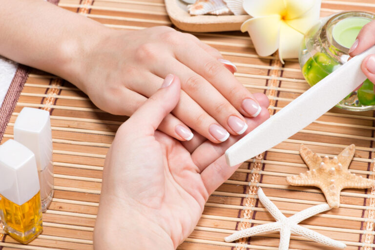 woman nail salon receiving manicure by beautician beauty treatment concept