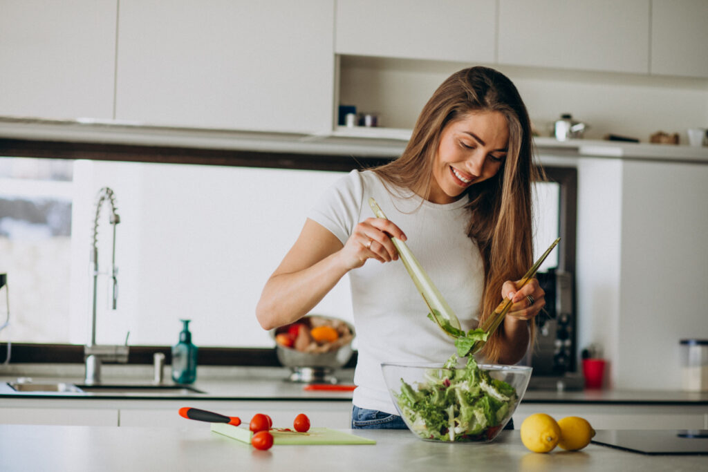 young woman making salad kitchen