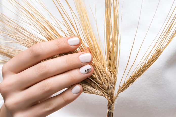female hand with white nail design close up