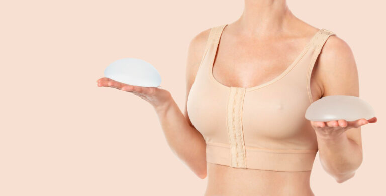 woman wearing compressing bra after breast augmentation holding round implants