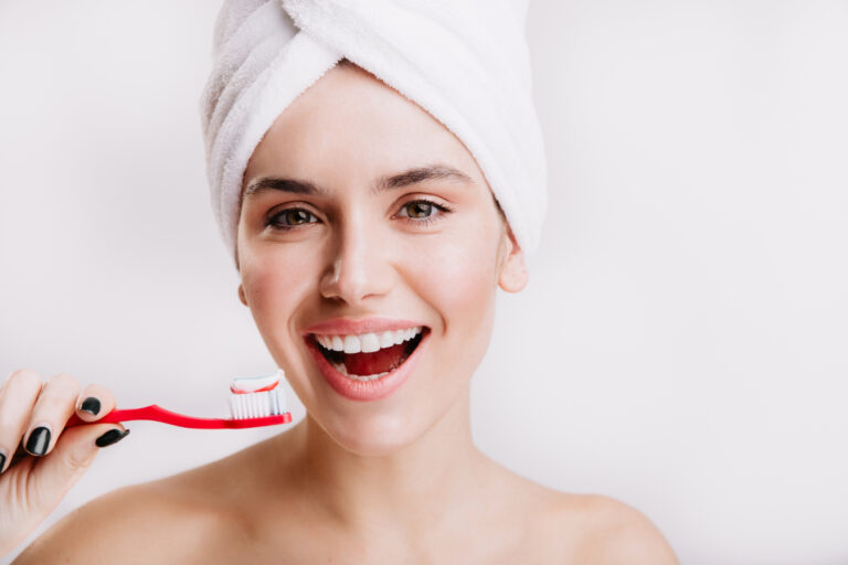 close up portrait contented girl with towel her head brunette with snow white smile is holding toothbrush