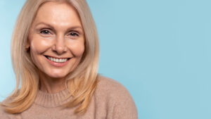 senior woman smiling against blue background